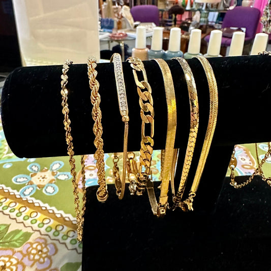 gold bracelets on black stand